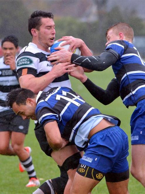 Southern loose forward Kyle Harris is tackled by Kaikorai winger Eti Slater and first five-eighth...