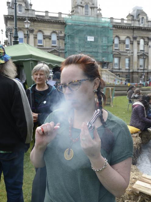 Whakamana Cannabis Museum acting manager Angela Gardiner smokes cannabis during J Day in the Octagon on Saturday. Photo: Gerard O'Brien.