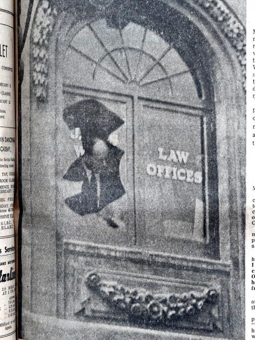 Detective Sergeant E.R. Tyson examines the window that was shattered by the blast in James Ward's office. Photo: Staff Photographer