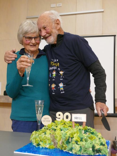 Barb Simpson raises a glass with her husband, Neill, at his surprise 90th birthday party in...