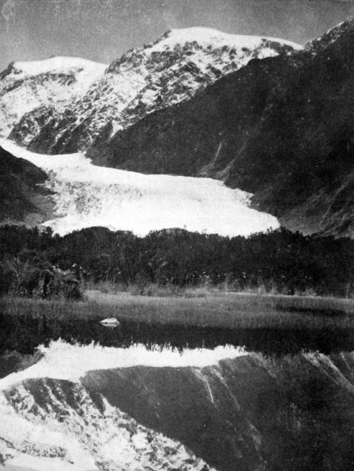 The terminal face of Franz Josef Glacier is reflected in Peter’s Pool. Otago Witness, 18.12.1923