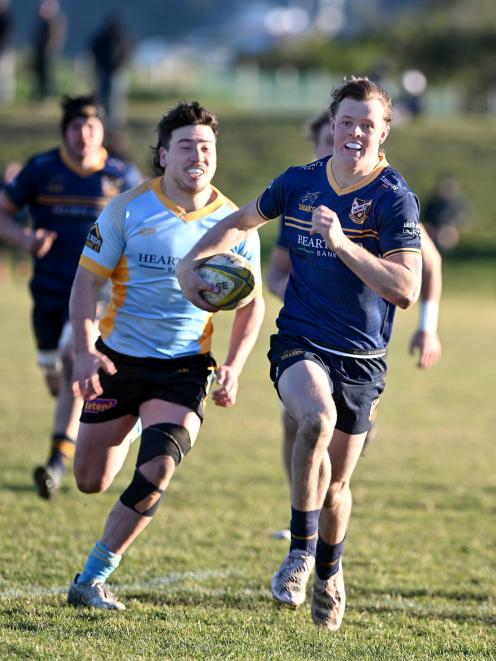 Dunedin fullback Joshua Augustine makes a break, pursued by University wing Mac Harris. 