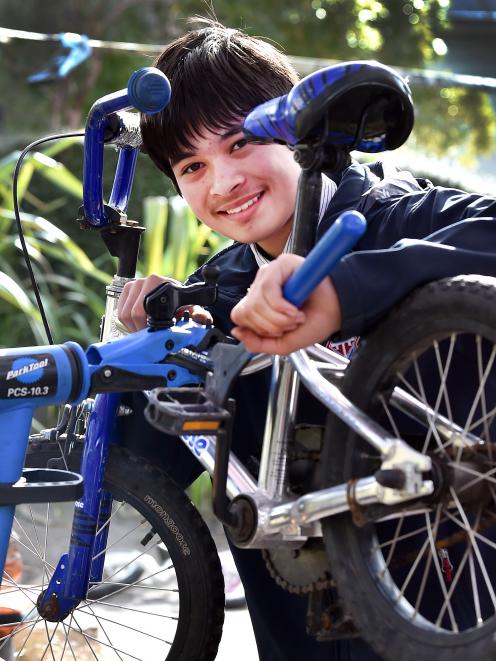 Trinity Catholic College student Cooper Pauley, 14, fixes a bike for children to ride at the...