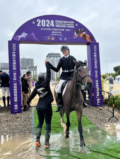 New Zealand Pony Club coach Tui Willson, of Cromwell, congratulates Georgia Lewis, riding  Blue...