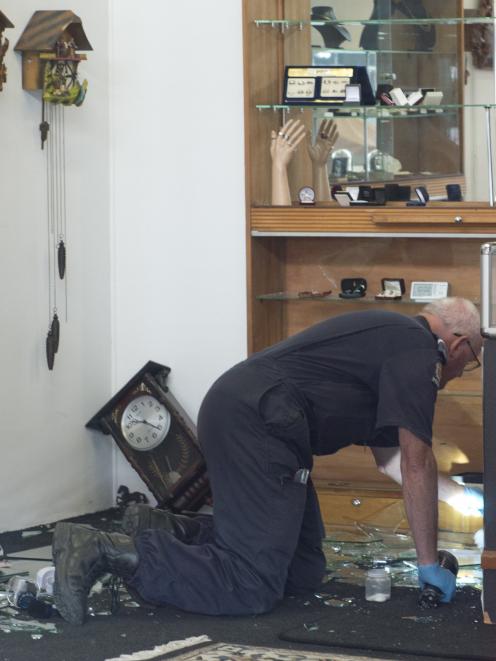 A police officer examines the scene of a burglary at Southern Cross Jewellers in Princes St  in...