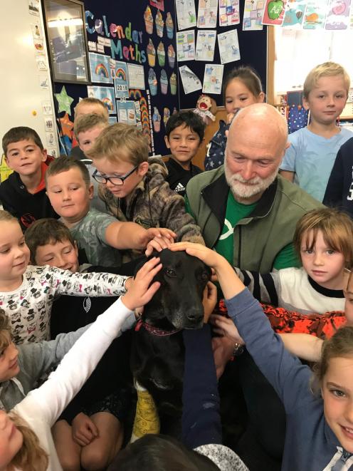 Outram School children surround Meg "the megadog'' and Andy Cunningham during their visit on...