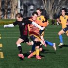 Logan Park footballer Sam Heron gets past Taieri goalkeeper Murray Boyne and defenders Jack...