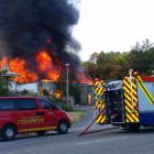 A beekeeper's business near Alexandra is engulfed in flames on Saturday. Photo by Mark Grimward.