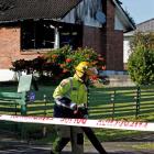 A firefighter outside the Auckland home where four children died. Another three people are in a...