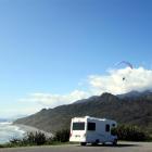 A parapenter catches the thermals by a coastal lookout just north of Greymouth.  The busy tourist...