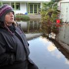 Aramoana League member Vicki Wilson stands next to one of about a dozen Aramoana properties which...