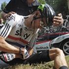Bradley Wiggins of Britain holds his left shoulder after crashing during the seventh stage of the...