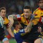 Cheifs Sonny Bill Williams offloads while held by Highlander Tamati Ellison at the Forsyth Barr...