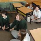 East Otago High School pupils sit on the floor and stay away from windows, as directed, during...