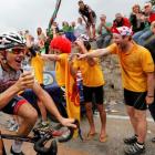 Lotto-Belisol rider Adam Hansen of Australia drinks a glass of beer as he climbs the Alpe d'Huez...