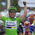 Mark Cavendish of Britain celebrates as he crosses the finish line ahead of Daniel Oss of Italy...