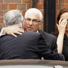 Mitch Winehouse, centre, the father of Amy Winehouse, is consoled as he arrives at Golders Green...