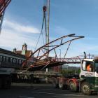 Part of the demolished Dunedin Railway Station footbridge is loaded to be carted away after it...