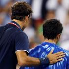 Roger Federer of Switzerland (L) pats Bjorn Phau of Germany on the back after defeating him at...