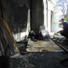 Specialist fire investigator Mike Harrison sieves through debris from a suspicious fire in Milton...