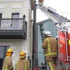 A member of the fire brigade examines the chimney at Eichardt's Private Hotel yesterday. Photo by...