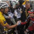 Thor Hushovd of Norway, wearing the overall leader's yellow jersey, and Cadel Evans of Australia,...