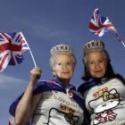 Two women, wearing masks depicting Britain's Queen Elizabeth, pose for a picture during a Jubilee...