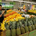 An employee checks the prices of lemons at a Whole Foods store. The US Whole Foods chain was...
