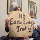 Margaret Wilkinson holds up a sign during the Dunedin City Council’s debate on allowing Easter...