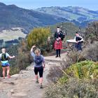 Paula Brown (centre), of Bluff, does an impromptu Highland fling at the peak of Mt Cargill in...