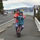 Lucy Goldsmith rides her electric scooter with daughter Freya Lester (6) on the Vauxhall to...