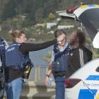 Police rinse the face of a man who was pepper-sprayed after fleeing police in Dunedin yesterday....