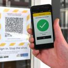 A man uses an app on his phone to scan the Covid-19 tracer QR code at a Dunedin business. Photo:...