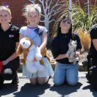 Zoey Hill (9, centre left) and Georgia Fehsenfeld (8) meet medical detection dogs Magic (2, left)...