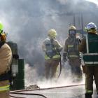 Charred remains  . . . Rangiora Volunteer firemen continue to dampen down the remains of a garage...