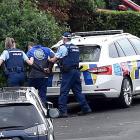 A man is led away from Heriot Row after armed police locked down the central Dunedin street in...