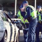 Police stop vehicles at a checkpoint in Crawford St, Dunedin, yesterday morning. PHOTO: PETER...