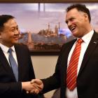 Shanghai vice-mayor Hua Yuan and Dunedin Mayor Jules Radich shake hands in front of a photo of...