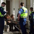 Police talk to boarding house residents after an alleged altercation. Photo: Stephen Jaquiery