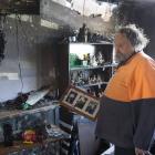 Oamaru man Neville Bryant looks through the remains of his living room after their family home...