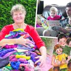 Palmerston artist and author Alicia Hall holds together the huge pile of knitting she has created...