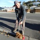 Douglas Cottages resident Russell Richards sweeps the path and surrounding areas free of autumn...