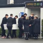 Mourners, including brother Jackson Garden-Bachop (rear left), carry the casket into the memorial...