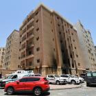 Emergency services outside a building damaged by a deadly fire, in Mangaf, southern Kuwait. Photo...