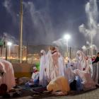 Muslim pilgrims pray as sprinklers spray water to cool them down amid extremely hot weather,...