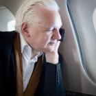 Julian Assange on the phone with wife Stella aboard a private jet to Canberra on Wednesday. Photo...
