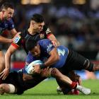 Akira Ioane of the Blues is tackled by Shaun Stevenson of the Chiefs during the Super Rugby...