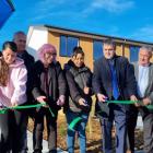 (From left) A Ngāi Tūāhuriri whānau member moving into one of the houses, with Barry Bragg, Cate...