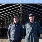 Richard Peirce and his son Alex stand outside the freestall barn on their family farm Riverside,...