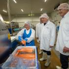 Prime Minister Christopher Luxon (centre) and Mt Cook Alpine Salmon general manager processing...